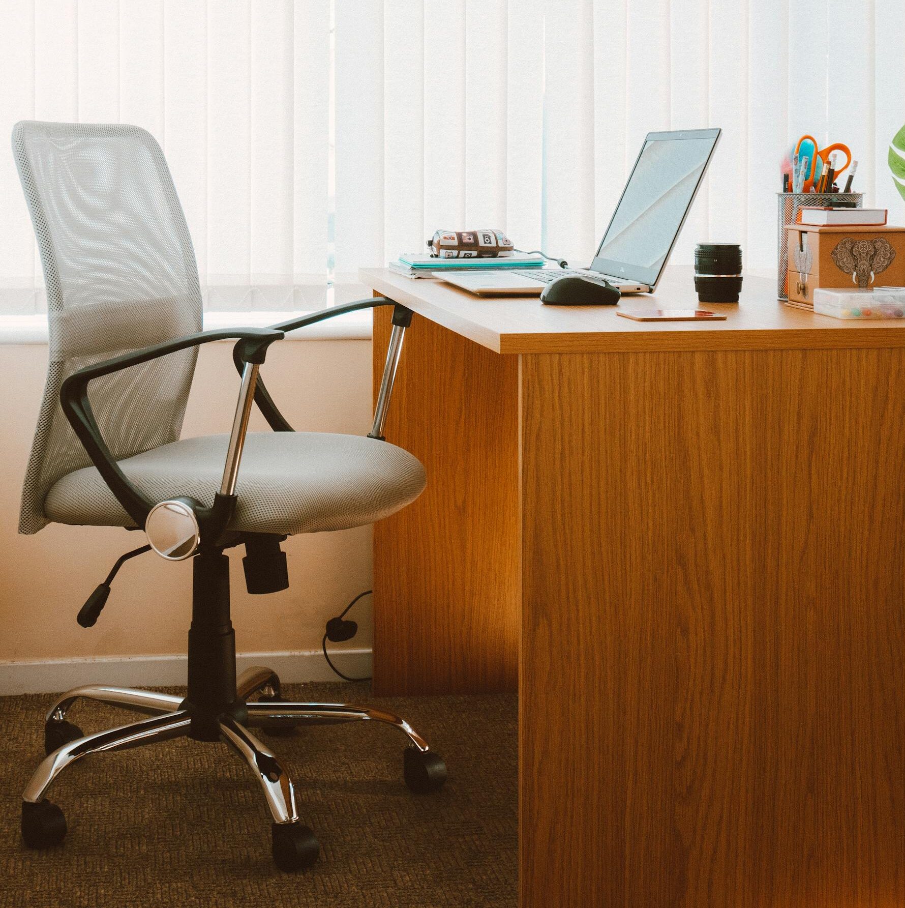 A tranquil modern home office featuring a wooden desk, ergonomic chair, and soft natural light.