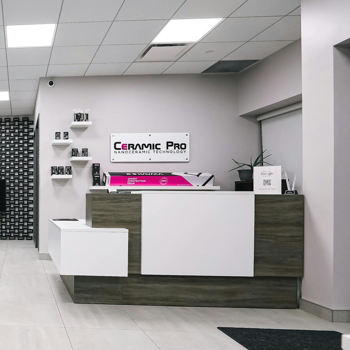 A sleek and modern car detailing shop interior featuring a waiting area and receptionist desk.